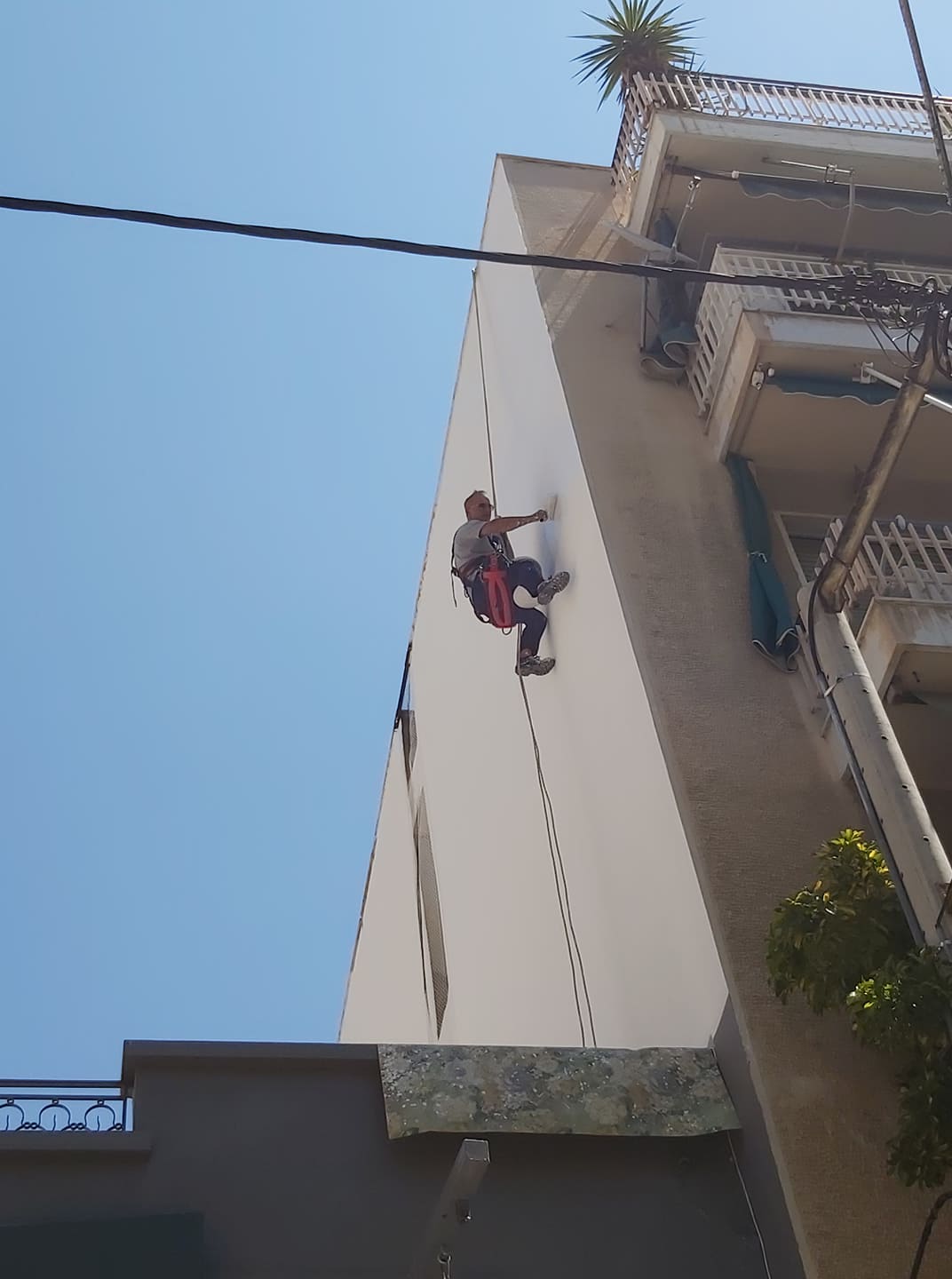 βάψιμο πλαινής όψης πολυκατοικίας με χρήση σχοινιών